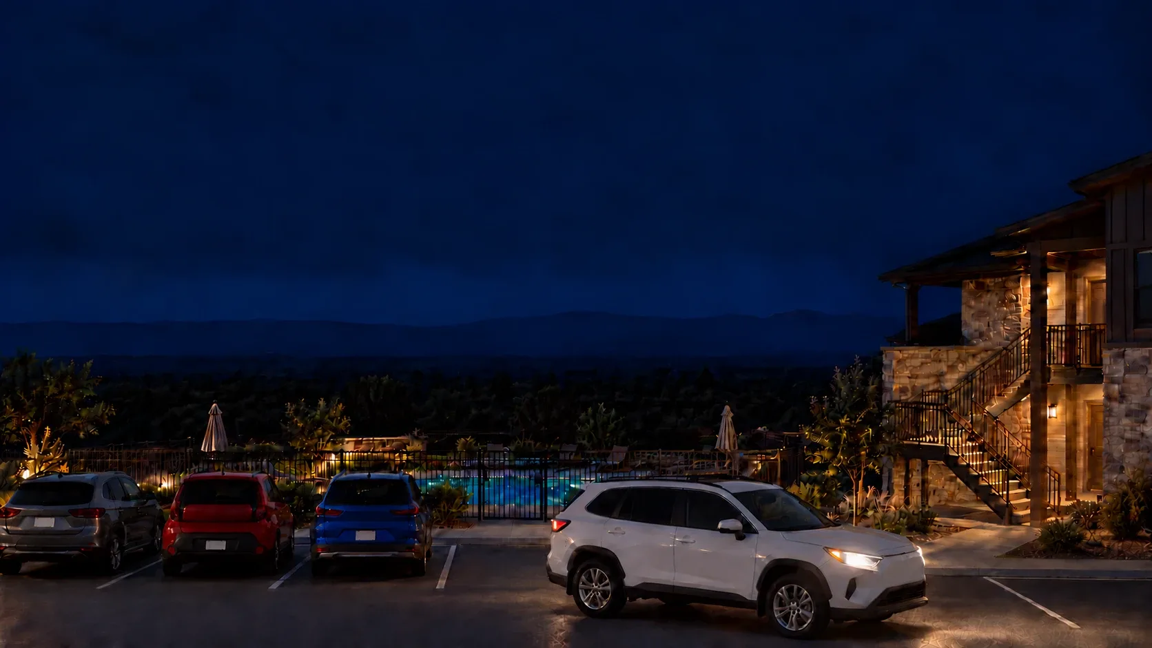 A white SUV with an unlit amber light bar driving slowly past a row of parked cars at night, the pool and a stair behind. A generated scene.